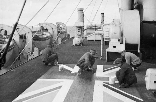 Lascars painting a Union flag on the deck of the P&O liner 'Chitral' (National Maritime Museum Photographic Collections).